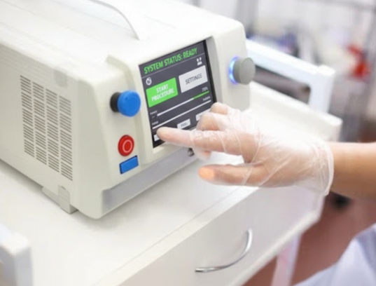 Nurse operating patient monitor with blue gloves